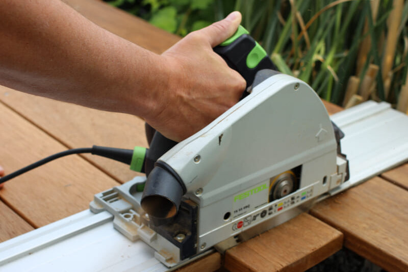 Präzises Holz sägen mit einer grünen Tauchsäge als wichtiges Werkzeug für anspruchsvolle Projekte im Außenbereich